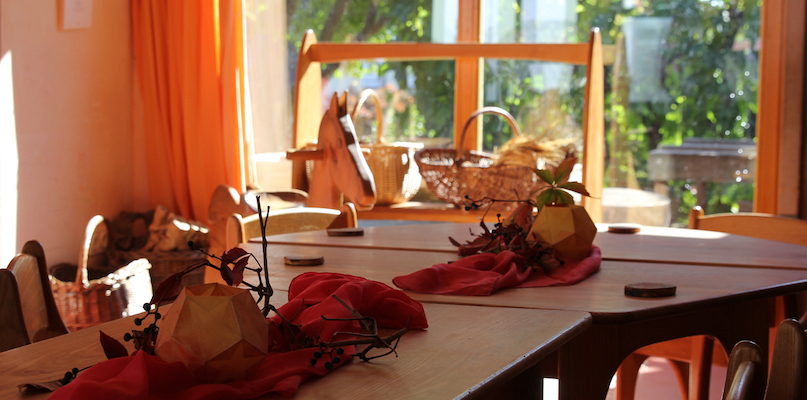 Blick in den Gruppenraum mit herbstlich geschmücktem Tisch aus Naturmaterialien